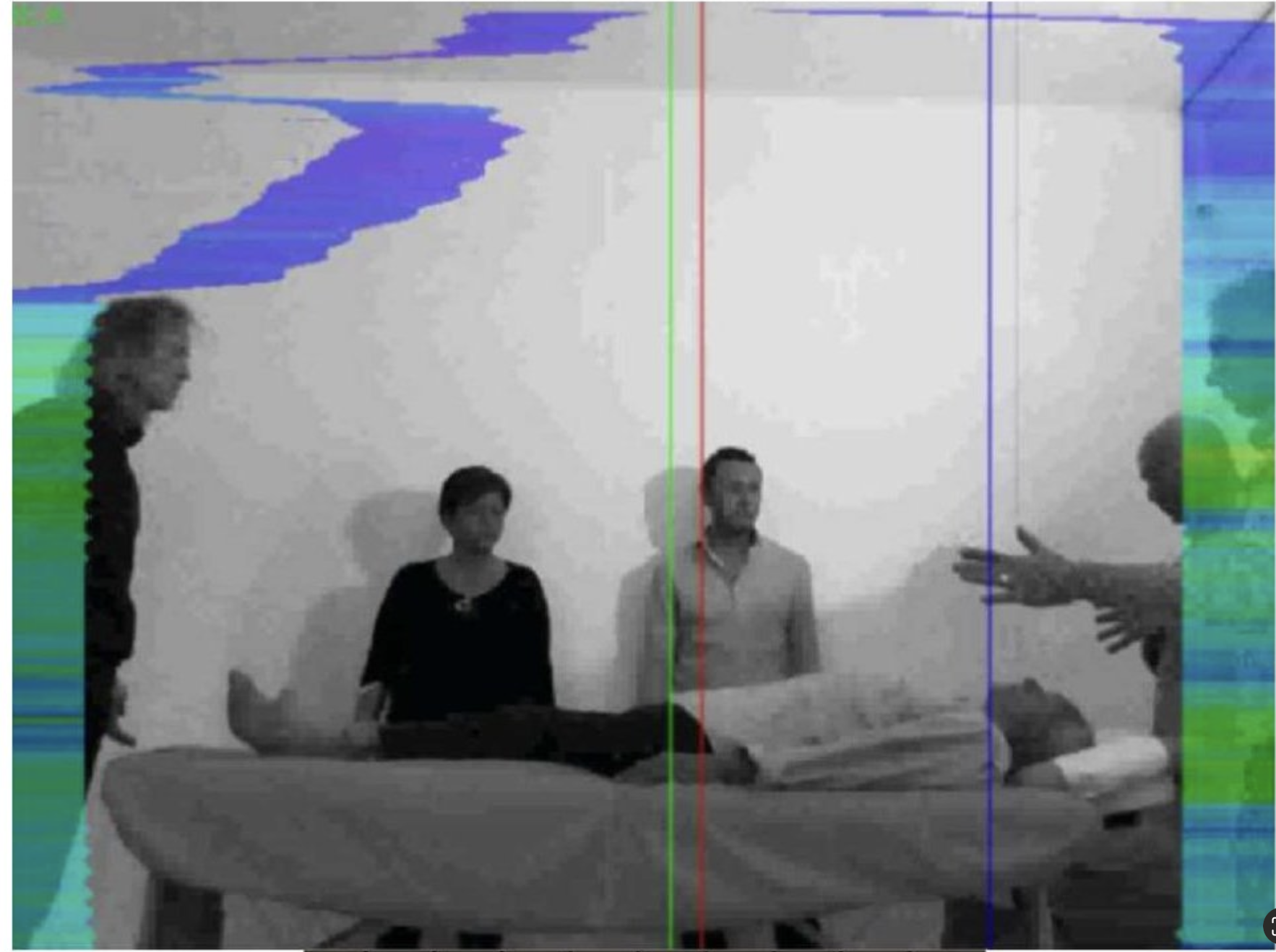TRV camera image during Divine Straightening session — practitioner emitting low-frequency coherent field, patient on table